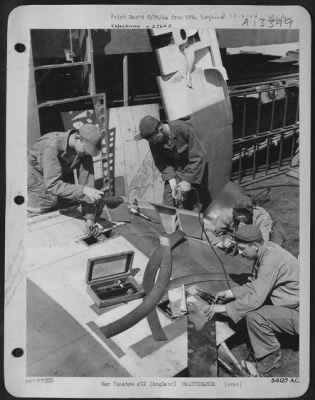 Thumbnail for General > A flak punctured rudder is mended by these four members of the sheet metal section of the Liberator Bomber Group commanded by Colonel Luther J. Fairbanks of Burt, Iowa. From left to right: Sgt Donald H. Rasor, 801 DeHaven Street, San Fernando