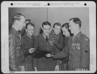 Thumbnail for Miscellaneous > Left To Right: S/Sgt Morris Hall Of Sanger, Calif., Presents A Wooden Model Of A Bomber To S/Sgt Oliver R. Germann, Of Moran, Wyo., As S/Sgt. Fred B. Mellums, Springhill, Tenn., S/Sgt. Lonnie L. Ackerman, Fox, Ark., T/Sgt. Buford R. Smith, Insul, Ky., And