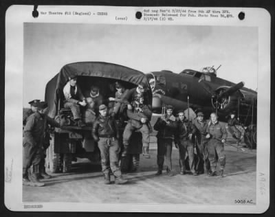 Consolidated > Guns and other paraphernalia of a heavy bomber are gathered up by this returning 8th AF Combat crew as they board the truck for the briefing office.