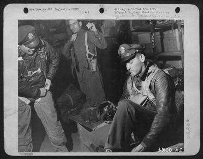 Consolidated > Hurrying to get ready for a mission hastily prepared to aid the invasion forces, three airmen don their fighting clothes at a Boeing B-17 Flying ofrtress base in England. They are: 2nd Lt. James G. Manion, Rochester, N.Y., navigator, left: 2nd Lt.