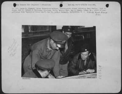 General > Lt. Col. James M. Stewart, Group Operations Officer, interrogates airmen returning from Berlin. Left to right: 2nd Lt. Robert F. Sullivan, Chicopee Falls, Mass.; Capt. Ray L. Sears, Tomar, Mo., pilot of Consolidated B-24 "Spirit of Notre Dame"; 1st