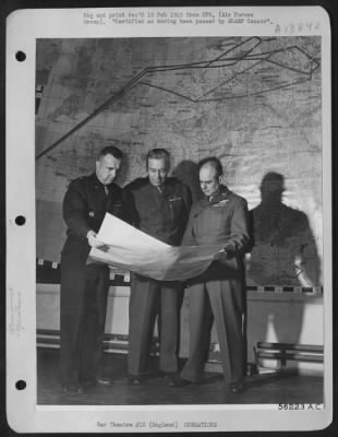 General > The Commanding General of the U.S. 8th AF, Lt. General James Doolittle, looks over a weather map with two members of his staff. Standing in front of the route map of a Berlin mission, Gen. Doolittle confers with Brig. Gen. Charles Y. Banfill