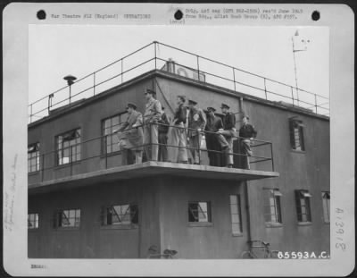 General > Officers Of A 401St Bomb Group Peer Into The Skies To Count Planes Returning From A Bombing Operation Over Enemy-Held Territory.  The Officers Stand On The Catwalk Of A Control Tower Where They Are Able To Maintain Constant Radio Contact With The Planes.