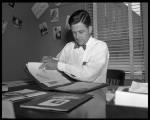 Jake Pickle seated at desk looking through notebook..jpg