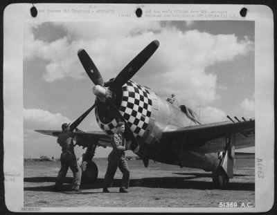 Republic > PULLIN PROP THRU . . . Preparatory to starting engine of P-47 Thunderbolt piloted by Capt. Qunice L. Brown, leading fighter pilot with 13 kills to his credit, Crew chief T/Sgt. Bill C. Jensen of Superior, Neb., (left) and Asst., crew chief Cpl.