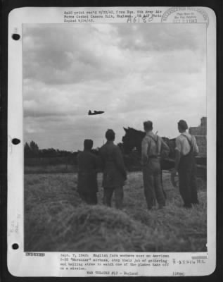 Martin > English farm workers near an American B-26 "Marauder" airbase, stop their job of gathering & bailing straw to watch one of the planes take off on a mission. 7 Sept. 1943. Left to right-back to camera, are: Land Army girl worker E. Brant, of London