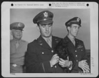 General Henry H. Arnold, Commanding General of the Army Air forces and Capt. James A. Verinia and "Stuka", and Capt. Charles B. Leighton, members of the crew of the Memphis Belle, a Flying ofrtress which made twenty five bombing missions - Page 1