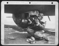 T/Sgt. Robert M. Dawson, ball turret gunner on a Flying ofrtress, takes barrel out after flight. - Page 1
