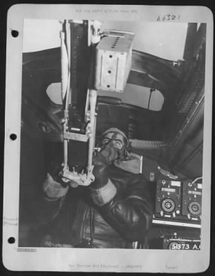 General > S/Sgt. Louis Kiss, radio and tail gunner, of Storres, Conn., holder of DFC, and Air Medal and 3 clusters manning the radioroom gun thru the hatch.