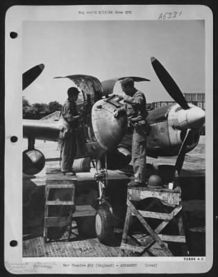 General > Sgt. Sidney Simpkins, armorer, St. Louis, Mo., shown jamming cleaning rod into barrel of .50 caliber Lockheed P-38 Lightning gun while crew chief T/Sgt. Alvin L. Archer, Houston, Texas, inspects engine of P-38 which has only minutes ago returned