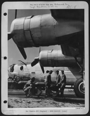 General > 500-pounders are lifted by hand by Ordnance crew from bomb trailer to be placed onto cradle where fins are attached. A hand trailer is then  slipped under the cradle and wheeled to Consolidated B-24 bomb-bay. The bomb service truck with bomb trailer