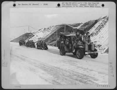 General > Ninth Air force Lockheed P-38 Lightning fighter-bomber pilots of the 367th group, cooperating with U.S. Third Army troops, have contrived a sleigh train for transportation from briefing hut to dispersal areas. A jeep crammed with pilots leaves