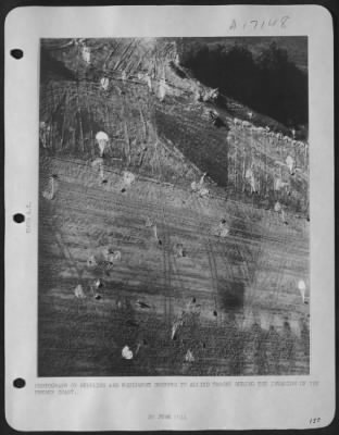 General > This photograph made from a Ninth Air Force Photographic Plane shows parachutes on the ground with parapacks and cannisters still attached to them. These were dropped from 9th Air Force Troop Carrier "Skytrains" on a newly constructed emergency