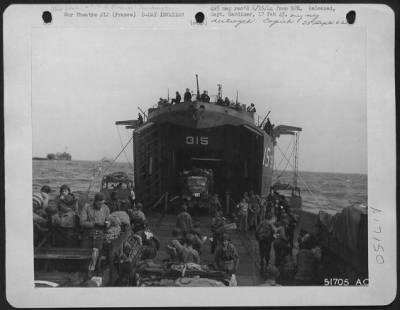 General > A Navy LST boat with its yawing doors is pictured on the Northern Coast of France unloading its supplies, vehicles and men to keep up the constant flow from England. These boats shuttle back and ofrth day and night under an air cover
