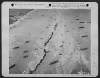 American Liberty shiops were deliberately scuttled off the beaches to provide makeshift breakwaters during the early days of the invasion somewhere in France. This scene shows 13 Liberty ships ofrmed into a protecting screen for the vessels - Page 1