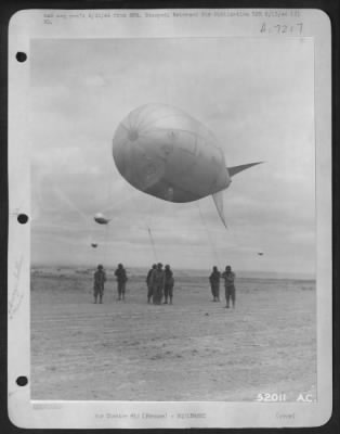 General > for protection against enemy strafing on the French coast, these men of the Anti-aircraft balloon squadron are shown in the process of hoisting up another to join those already in service.