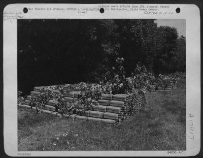 Thumbnail for Supplies > "Somewhere in France"--These five-gallon fuel tanks, hastily camouflaged with foliage from nearby trees are part of the 9th Air Force Service Command supply dump in Normandy. The dump, set up within 24 hours of D-Day, will supply aviation gas