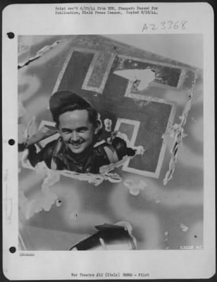 Consolidated > 2nd Lt. Joseph R. Konieczny, 23 of 324 Ave. E. Bayonne, N.J., pilot of a 15th AAF Boeing B-17 Flying Fortress, wearing his good luck cap which is standard equipment for him on his combat missions, is shown here looking through a hole in the tail of a