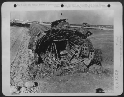 Consolidated > ITALY-Although pierced steel plank forms an all-weather surface, the earth base under it is subject to the vagaries of Nature. Here an entire section of assembled plank runway is rolled back so that the base can be regarded. The planks will outlast