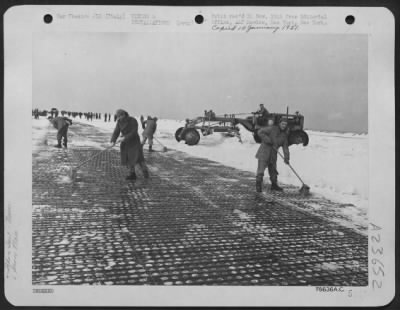 Consolidated > Every available tool was used to clear the runway of an airfield below sea level maintained by an engineers aviation battalion in Italy following its first experience with a snow storm. The engineers are working here with large straw brooms and a