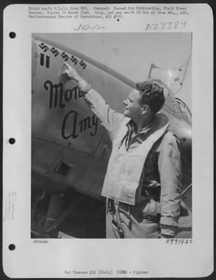 Consolidated > 2Nd Lt. Herbert B. Hatch Of Stockton, Calif. A Lockheed P-38 Lightning Fighter Pilot Of The Mediterranean Allied Afs In Italy, Proudly Points To The 5 Swastikas On The Nose Of His Plane, That Proclaim His Victory Over 5 Hun Aircraft That He Shot Down In A