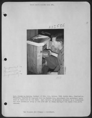 Consolidated > Sgt. Joseph L. Byrnes, Husband Of Mrs. J.L. Byrnes, 709 1/2 Garvin Ave., Charleston, Va, Reaches In Cupboard For His Toilet Kit, Underneath The Porcelain Basin That He Installed In His Tent.  Sgt. Byrnes, An Airplane Mechanic In A Consolidated B-24 Libera