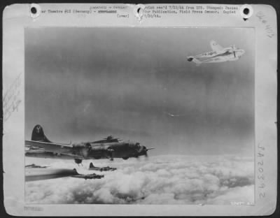 Consolidated > One of the Lockheed P-38 Lightnings that escorted these Boeing B-17 Flying Fortresses of the 15th AAF over Bleckhammer, Germany, on 7 July 1944 was hit by flak. With its prop feathered, it returned to its base under the protection of the heavy