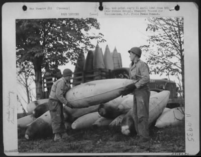 Consolidated > Ground Crewmen Unload Captured German Belly Tanks Preparatory To Loading The Containers With Gasoline And A Jell Like Substance Which Will Convert Them Into A New Type Incendiary Bomb For Fighter Bombers Of Major General Hoyt S. Vandenberg'S 9Th Af.  L To