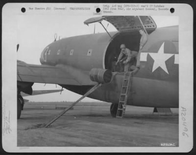 Consolidated > The Us 7Th Army'S Call For Gasoline Is Answered With Action By Planes And Soliders Of The 9Th Troop Carrier Command As A Crew Member Sends A 40 Gallon Drum Of 100 Octane Gasoline Out Of The Plane On A Set Of Steel Rails At An Air Base Somewhere In Germany