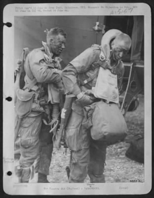 Consolidated > MEN FROM MARS . . . . Rigged up, blackened and heavily armed these men make final adjustments to their equipment in a last minute check up before taking off from a Ninth Air force Trooper Carrier Command Base somewhere in England.