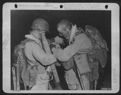 Thumbnail for Consolidated > GREAT MOMENT ARRIVES-Paratroopers check each others equipment before boarding giant troop carrier C-47/ Some Paratroopers carried parts of large field rifles into Hitler's Europe.