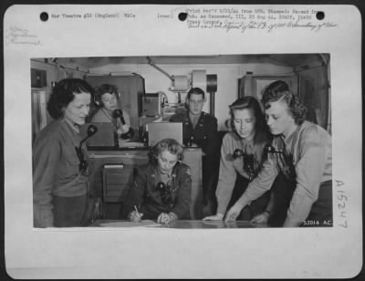 Consolidated > ENGLAND-Bombers returning from missions over Germany which have been damaged of have lost their bearings receive new directions from these Wacs in a mobile control unit truck. The Wacs standing around the table are plotters who by means of strings