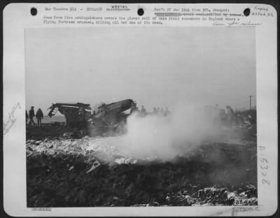 Consolidated > ofam from fire extinguishers covers the plowed soil of this field somewhere in England where a Flying ofrtress crashed, killing all but one of its crew.