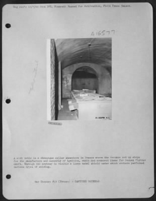 General > A work table in a champagne cellar somewhere in France where the Germans set up shops for the manufacture and assembly of ignition, radio and armament items for German fighter craft. Through the archway is visible a large metal shield under which