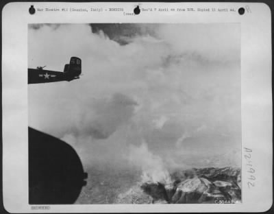 Thumbnail for Consolidated > With the Benedictine monastery at Cassino smoking beneath, a B-25 Mitchell of the famed "Invader" group of the 12th AAF flies homeward after blasting the Germans from the stronghold in front of the 5th Army.