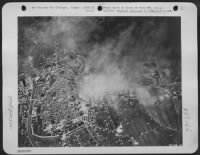 B-25 Mitchell Bombers of the 12th AF recently hit the important railroad yards at Foligno, Italy. The thousand-pound bombs dropped by the Mitchells leave a thick pall of smoke over the entire target area as many direct hits are scored. The - Page 1