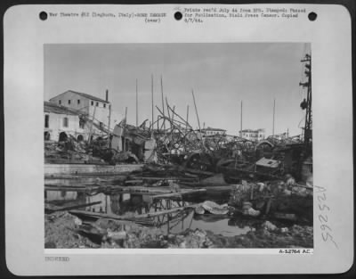 Thumbnail for Consolidated > Twisted steel, the skeletons of once active buildings that were used by the Hun to bolster his positions on the Italian front, remain at Leghorn Harbor, Italy, as these facilities were blasted to Kingdom Come by Mediterranean Allied Air Forces.