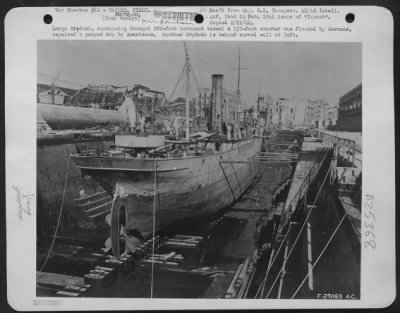 Consolidated > Large drydock, containing damaged 280-foot merchant vessel & 150-foot coaster was flooded by Germans, repaired & pumped dry by Americans. Another drydock is behind curved wall at left.