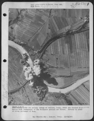 Consolidated > Bomb bursts cover the railway bridge at Orvieto, Italy, which was blasted by Martin B-26 (Marauders) of the Northwest African Air Forces. Orvieto is about 45 miles northwest of Rome.