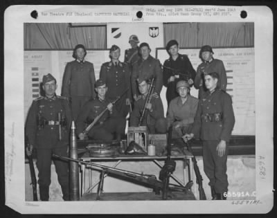 General > Men Of The 401St Bomb Group Who Are Wearing Captured German Uniforms Group Themselves Around A Display Of Captured Equipment.  England 6 August 1944.