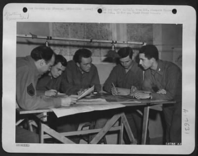 General > This operation is called plotting at a 9th AF Recon Unit somewhere in France. Left to right are: S/Sgt Fred W. Schiesser, Chicago, Ill.; Sgt Raymond J. Roser, Woodhaven, N.Y.; Cpl Forest E. Wilson, Champaign, Ill.; Sgt Francis B. Foley, Chicago, Ill.