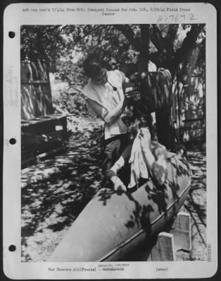 General > Lt. John Arnold, San Antonio, Texas, uses a salvaged gas tank as an improvised bath tub as Lt. James G. Burke of Ogden, Utah provides the running water.