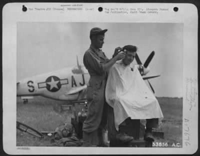General > A Mustang in the background, packing case for a chair and the sky for light are standard equipment for this barber at a 9th AF base in France. Barber is Sgt. Jerry H. Williams of Samaria, Idaho, while his customer is Sgt. Thomas Watters of Kearny