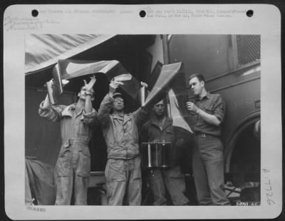 Operations & Mapping > Technicians at a photographic reconnaissance unit with the 9th AF in France examine a roll of aerial film made by a photo reconnaissance plane. Left to right are: Sgt Lonnie W. Cameron, Denver, Colo.; Cpl Carl Knox, Syracuse, N.Y.; Sgt Robert S.