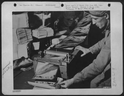 Processing > FRANCE--The guillotine cuts the continuous chain into individual prints which are stacked and bundled for the needs of the various users, and ready for the jeep run to the boys at the front. S/Sgt. Edward Miazga of Erie, Pa., counts and checks