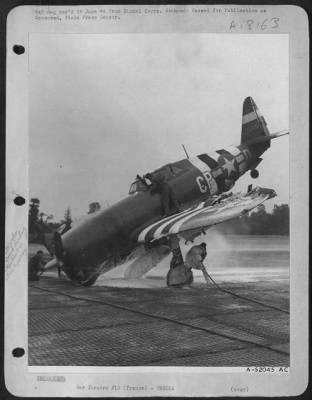 Thumbnail for General > Air Force ground crewmen use foamite to extinguish the fire started when this P-47 fighter, with riddled wing and an injured pilot, crash-landed on one of the new air bases in France.