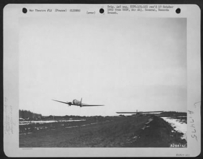General > A Douglas C-47 Of The 9Th Troop Carrier Command Flies Low Over A Field During A 'Snatch Pickup' Of A Cg-4A Glider, 'Old Canvas Sides' Somewhere In France.  3 February 1945.