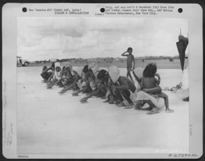 Consolidated > Before Camouflage Is Applied To The Newly Constructed Runway At Ondal Army Air Base I India, Natives Brush Off The Concrete To Remove All Foreign Matter In Order That The Camouflage Can Be Applied Properly.  305Th Service Group, 1943.