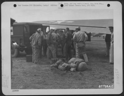 Thumbnail for Consolidated > Patients Who Have Been Evacuated From A Combat Area In A Douglas C-47 Ambulance Plane Of The 803Rd Air Evacuation Transport Squadron Are Loaded Into Waiting Ambulances At Calcutta, India. Note The Plane Marked With The Chinese Insignia (Background).