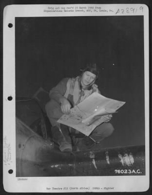 Consolidated > Lt. Bloomquist, pilot of the 90th Photographic Reconnaissance Wing, studies a map before taking off on a mission from an air base somewhere in North Africa.